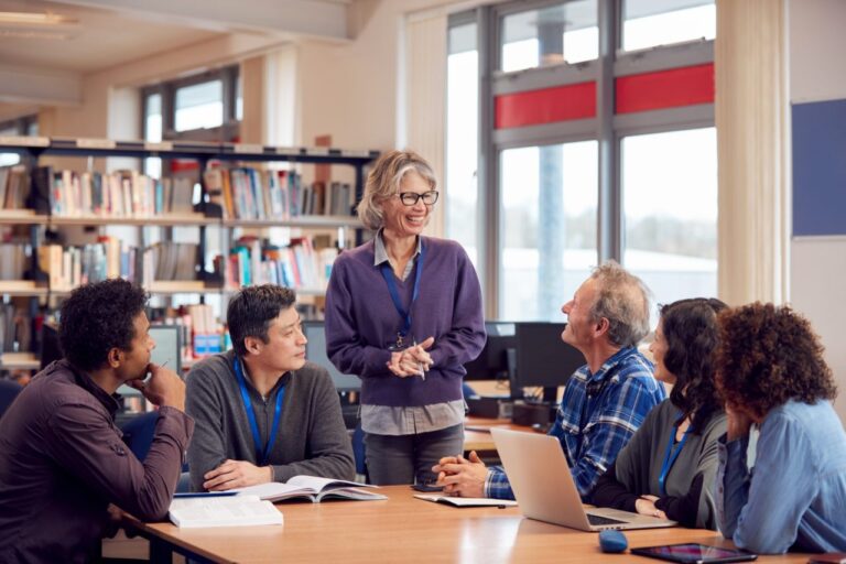 teacher-with-group-of-mature-adult-students-in-class-sit-around-table-and-work-in-college-library.jpg